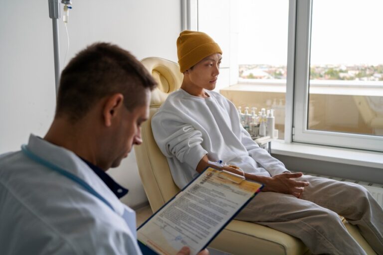 Cancer patient consulting with a pain management specialist during a treatment session in a modern healthcare clinic.