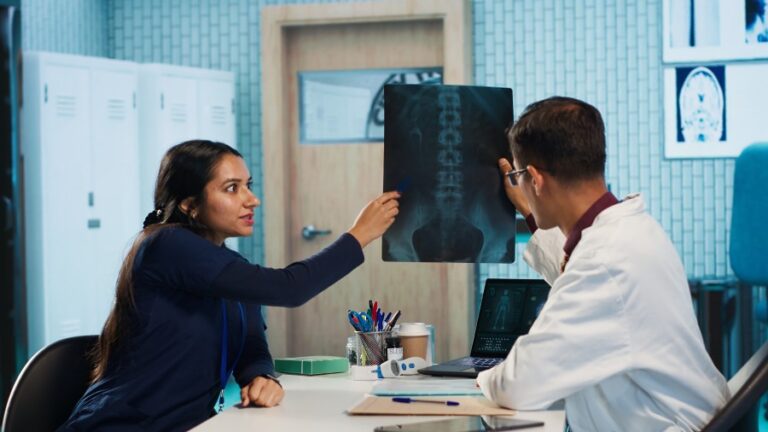 Patient consulting a spine specialist while reviewing a spine X-ray for back pain diagnosis and treatment in Delhi.